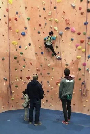 A staff member belaying a first-time climber